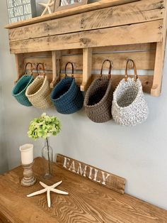 a wooden bench with four baskets hanging from it's hooks