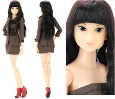 a doll with long black hair wearing a brown dress and red high heeled shoes