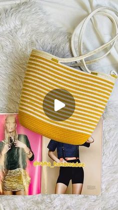 a yellow purse sitting on top of a bed next to an open book and magazine