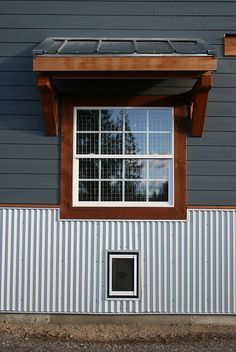 a small window on the side of a building with a solar panel in front of it