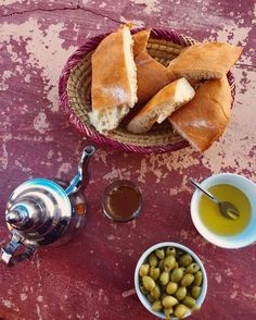 some bread and olives are on a table