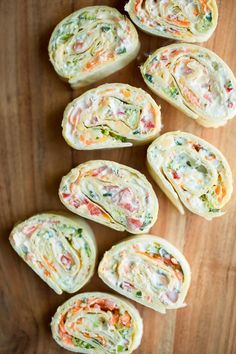 several pieces of food on a wooden surface with one cut in half and the other rolled up