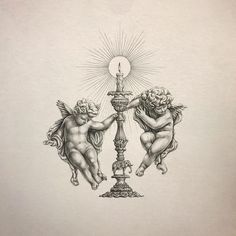 two cherubs sitting on top of a table next to a light pole with a candle