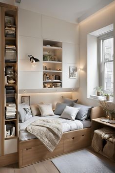 a bedroom with a bed, bookshelf and window in it's corner