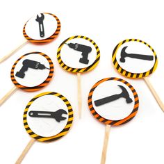 six cupcake toppers with black and orange construction tools on them, arranged in the shape of circle