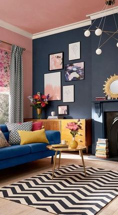 a living room with blue couches and pictures on the wall above it's fireplace