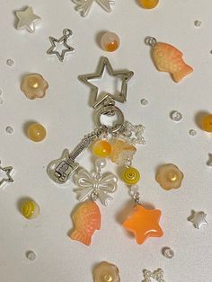 a bunch of charms that are laying on a white surface with stars and other objects