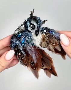 a person holding a small bird made out of feathers