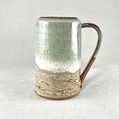 a green and white mug sitting on top of a table