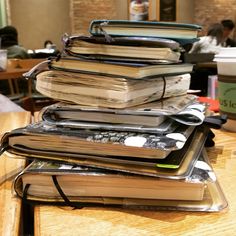 a stack of books sitting on top of a wooden table