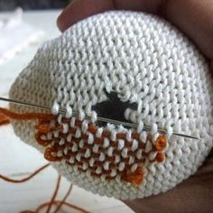 someone is knitting something with scissors in their hand and it looks like an eyeball