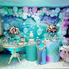 a mermaid themed birthday party with balloons and cake