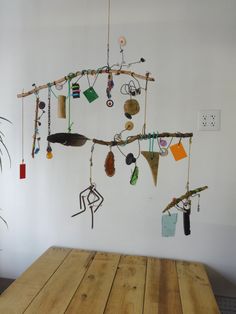 a wooden table sitting in front of a wall hanging with various items and decorations on it