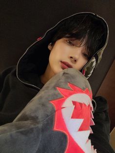 a boy in a black hoodie with a red and white dragon on his chest