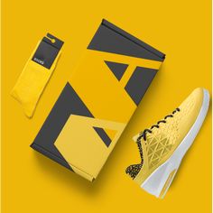 a pair of yellow sneakers next to a box and shoe laces on a yellow background