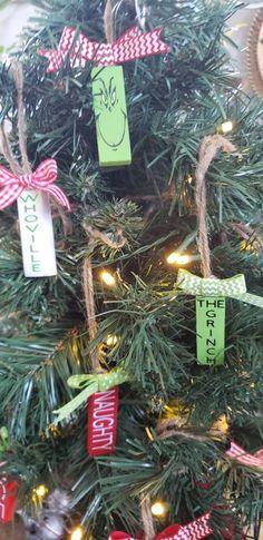 a christmas tree decorated with green and red ribbons, tags on the branches and an ornament hanging from it's top