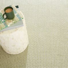 a stack of money sitting on top of a wooden stump next to a coffee mug