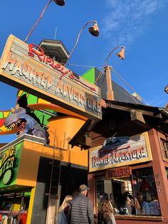 two people are walking past a colorful building with an awning on it's roof