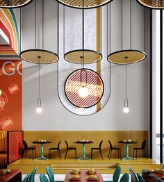 the interior of a restaurant with round lights hanging from the ceiling and colorful chairs on the tables