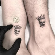 two people with matching tattoos on their legs, one has a crown and the other has a skull