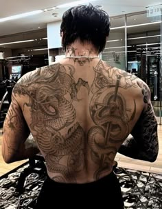 the back of a man with tattoos on his body