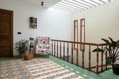 a chair sitting on top of a green floor next to a wooden banister