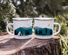 two camping mugs sitting on top of a tree stump