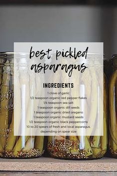 jars filled with pickled asparagus sitting on top of a wooden countertop