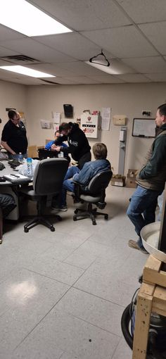 several people sitting at desks in an office