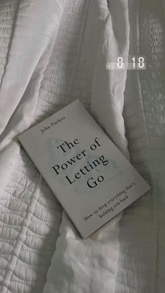 a book laying on top of a bed covered in white sheets with the title'the power of letting go '