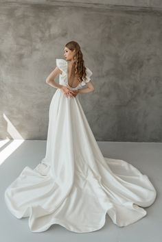 a woman in a white dress is standing on the floor with her back to the camera