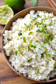 a bowl filled with rice next to chopsticks and lime