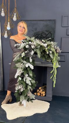 a woman standing next to a christmas wreath