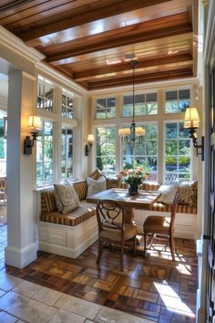 the sun shines through the windows in this dining room with wooden beams and wood flooring