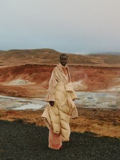 a woman standing on top of a rocky hillside