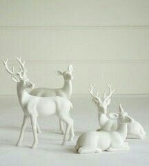 three white deer figurines sitting next to each other