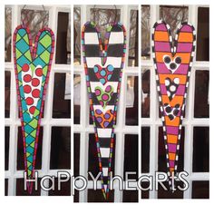 three colorful stained glass hearts hanging from a window