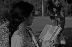 a woman sitting on a bench reading a book