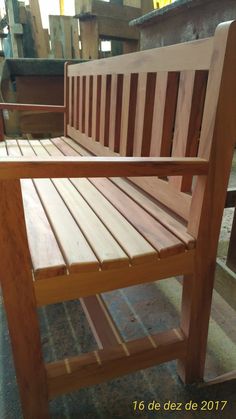 a wooden bench sitting on top of a floor next to a pile of wood planks