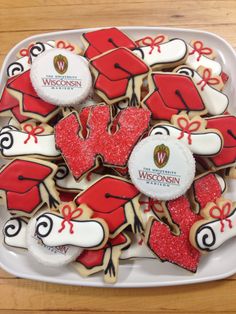 decorated cookies in the shape of hearts and bows on a platter with wisconsin logo