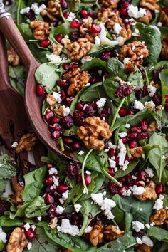 spinach salad with walnuts, feta cheese and cranberries in a wooden bowl