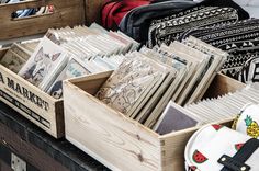 a wooden box filled with lots of cards next to other boxes full of papers and bags