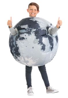 a young boy is holding an inflatable ball and giving the thumbs up sign