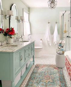 a bathroom with two sinks, a bathtub and a rug on the floor