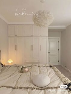 a white bed sitting in a bedroom next to a lamp and closets on either side of the bed