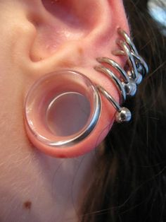 a close up of a person's ear with metal rings attached to it