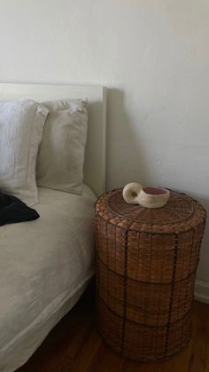 a wicker basket sitting on top of a bed next to a night stand