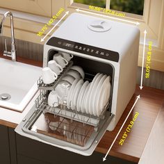 an open dishwasher with dishes in it on a kitchen counter next to a sink