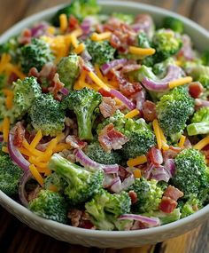 a bowl filled with broccoli and cheese on top of a wooden table