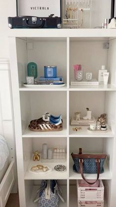 a white book shelf filled with lots of personal items on top of eachother